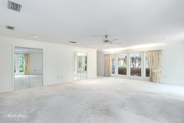 unfurnished room with a healthy amount of sunlight, light colored carpet, and ceiling fan