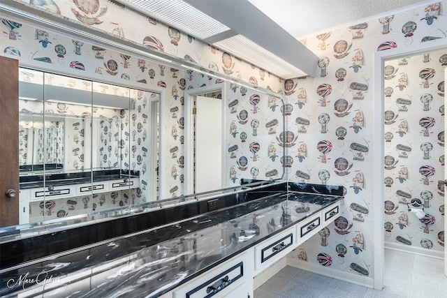 bathroom with tile patterned flooring and a textured ceiling