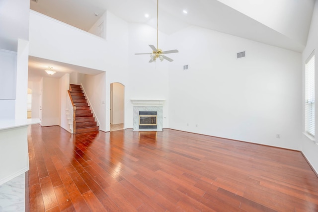 unfurnished living room featuring hardwood / wood-style flooring, a fireplace, plenty of natural light, and high vaulted ceiling