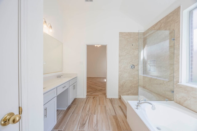 bathroom with vaulted ceiling, independent shower and bath, plenty of natural light, and vanity