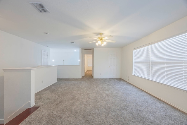 carpeted spare room featuring ceiling fan