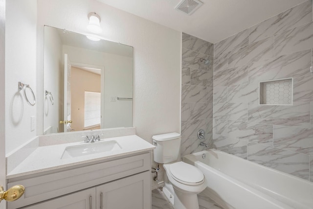 full bathroom featuring tiled shower / bath combo, vanity, and toilet