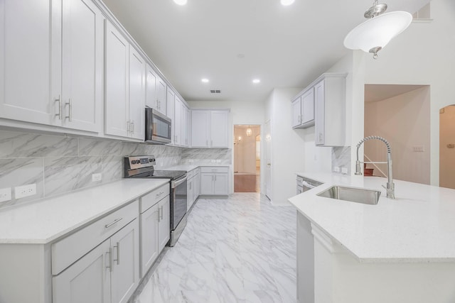 kitchen with pendant lighting, kitchen peninsula, sink, tasteful backsplash, and appliances with stainless steel finishes