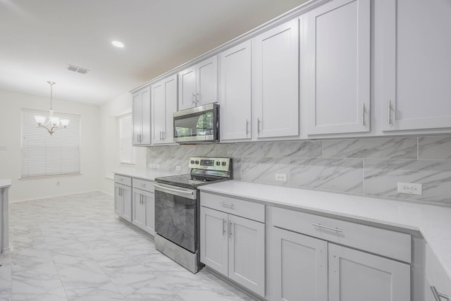 kitchen with decorative light fixtures, stainless steel appliances, backsplash, and a chandelier