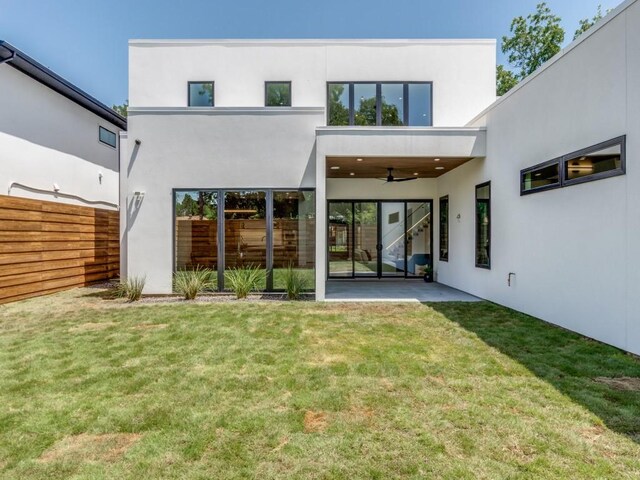 back of property featuring ceiling fan, a patio area, and a yard