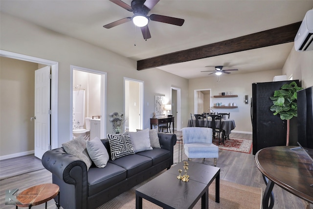 living room featuring beam ceiling, wood-type flooring, a wall unit AC, and ceiling fan