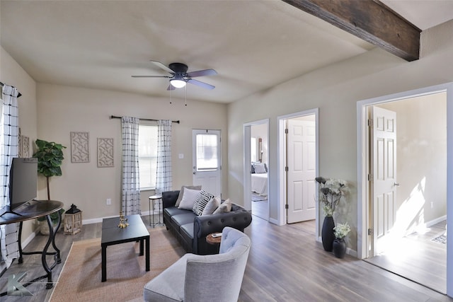 living room with hardwood / wood-style floors, beam ceiling, and ceiling fan