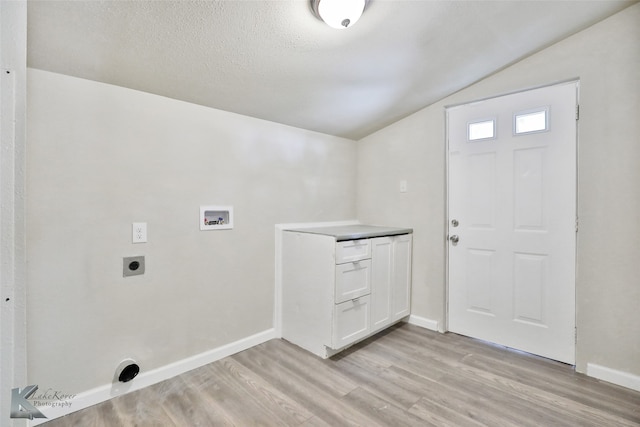 washroom featuring hookup for a washing machine, a textured ceiling, light hardwood / wood-style flooring, and hookup for an electric dryer