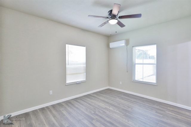 empty room with an AC wall unit, hardwood / wood-style floors, and ceiling fan