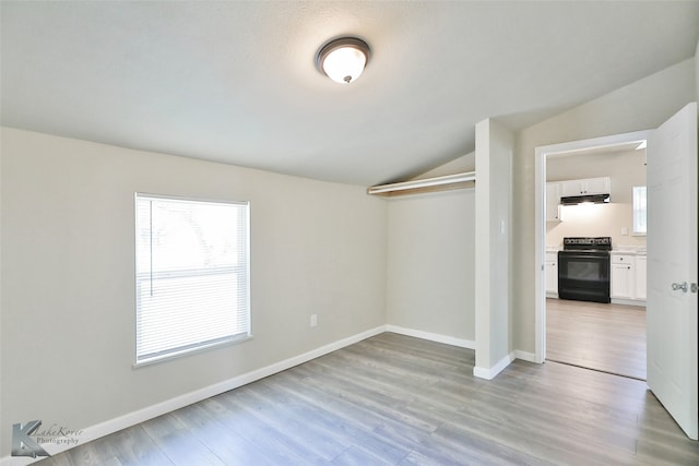 unfurnished room with light hardwood / wood-style flooring and vaulted ceiling