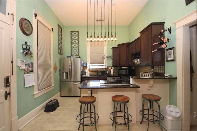 968 Mounce Rd, Grand Cane, LA 71032 - kitchen featuring a breakfast bar, dark brown cabinetry, stainless steel fridge, and decorative light fixtures