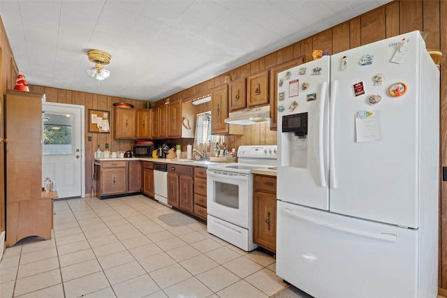 kitchen with a healthy amount of sunlight, sink, light tile patterned floors, and white appliances