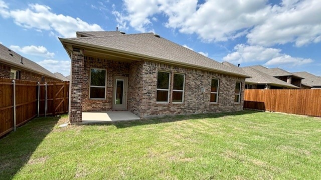 rear view of property featuring a patio and a yard