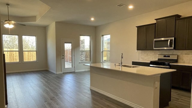 kitchen with a kitchen island with sink, appliances with stainless steel finishes, open floor plan, and a sink