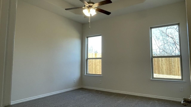 unfurnished room featuring dark carpet, baseboards, and ceiling fan