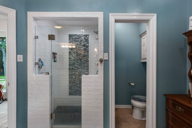 full bath with baseboards, toilet, and a shower stall