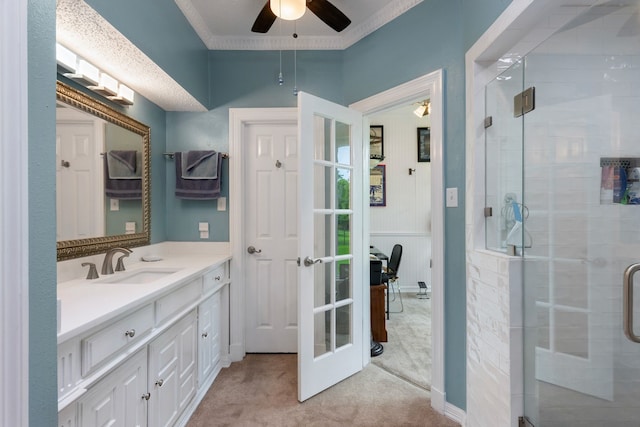 bathroom featuring french doors, an enclosed shower, vanity, ceiling fan, and crown molding