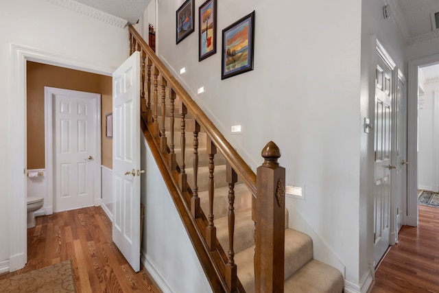 stairway featuring visible vents and wood finished floors