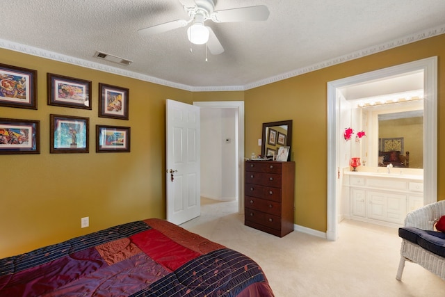 bedroom featuring ceiling fan, ensuite bathroom, crown molding, a textured ceiling, and light carpet