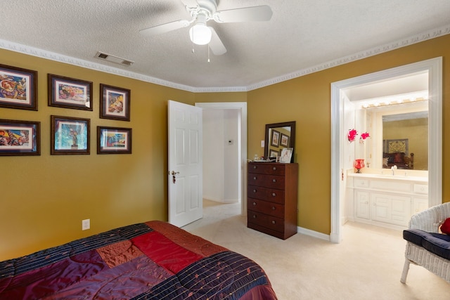 carpeted bedroom featuring visible vents, a sink, a textured ceiling, ensuite bath, and baseboards
