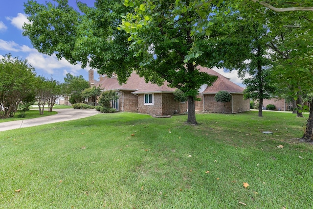 ranch-style house featuring a front lawn, concrete driveway, and brick siding