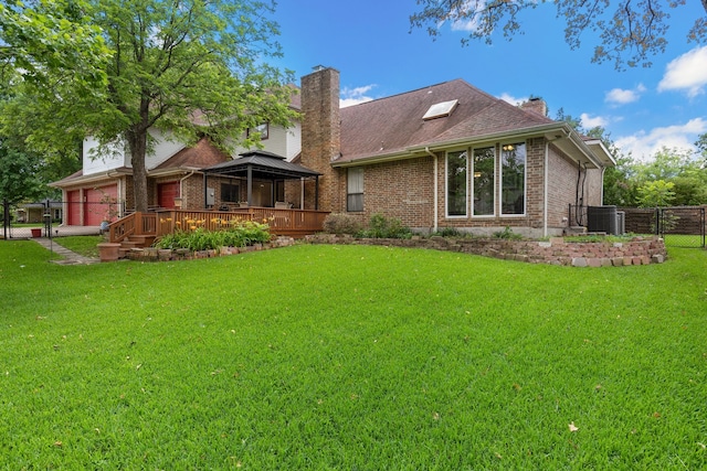 back of property with a gazebo, brick siding, a chimney, and a lawn