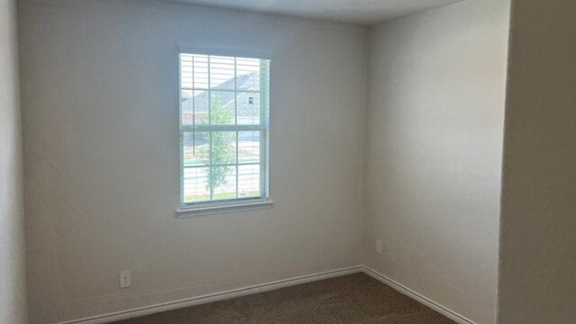 211 Bobcat Ln, Caddo Mills, TX 75135 - empty room featuring dark carpet and baseboards