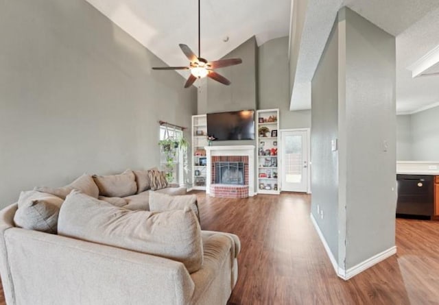 living room featuring ceiling fan, wood-type flooring, a fireplace, and high vaulted ceiling