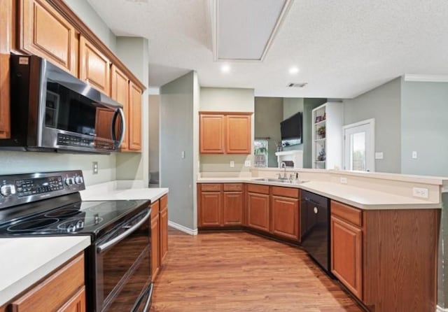 kitchen featuring a textured ceiling, light hardwood / wood-style floors, sink, and appliances with stainless steel finishes