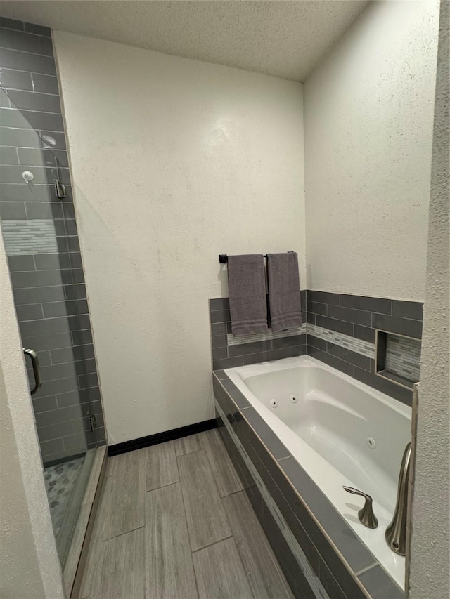 bathroom with plus walk in shower and a textured ceiling