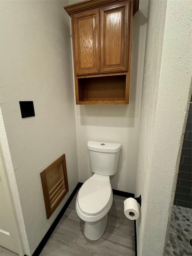 bathroom with tile patterned floors, toilet, and a shower