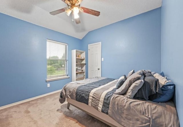 bedroom with a textured ceiling, carpet floors, ceiling fan, and lofted ceiling