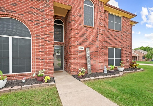 property entrance featuring a lawn