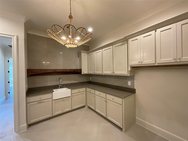 kitchen featuring a notable chandelier, crown molding, hanging light fixtures, and sink