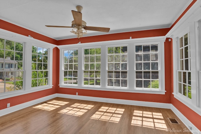 unfurnished sunroom with ceiling fan