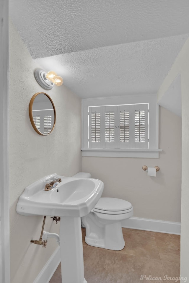 bathroom featuring tile patterned flooring, a textured ceiling, and toilet