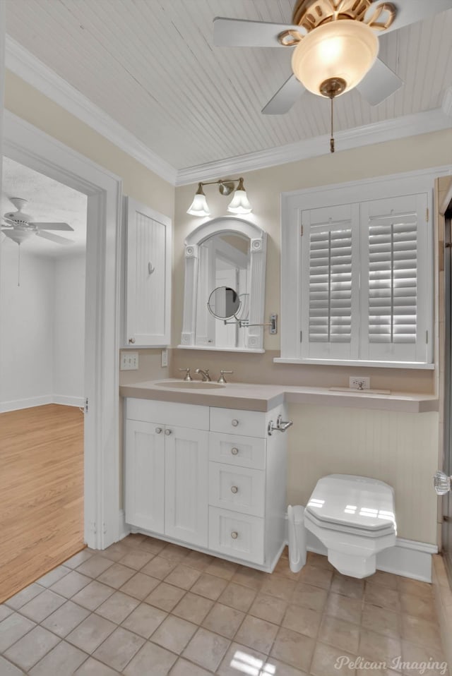 bathroom with tile patterned floors, toilet, vanity, and ornamental molding