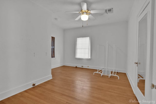 empty room with ceiling fan and light hardwood / wood-style flooring