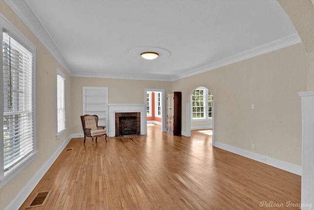 unfurnished living room with a fireplace, built in features, and ornamental molding