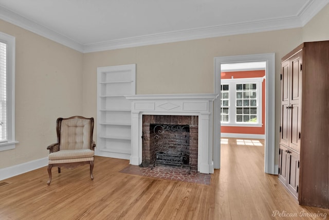 sitting room featuring built in shelves, a fireplace, and plenty of natural light