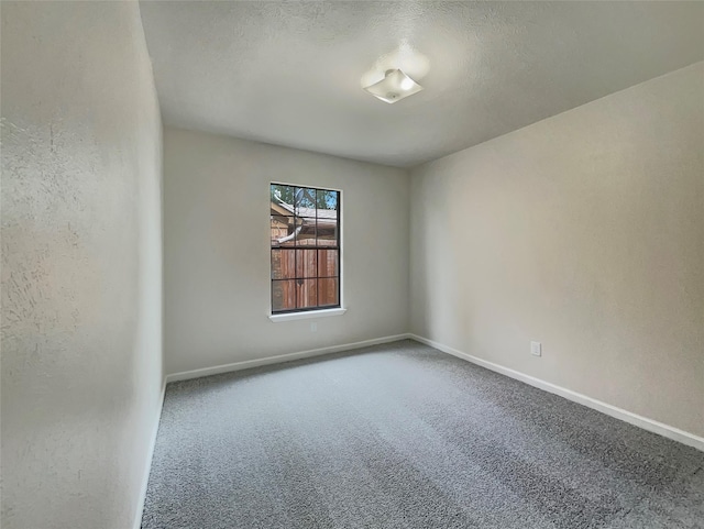 carpeted spare room with a textured ceiling