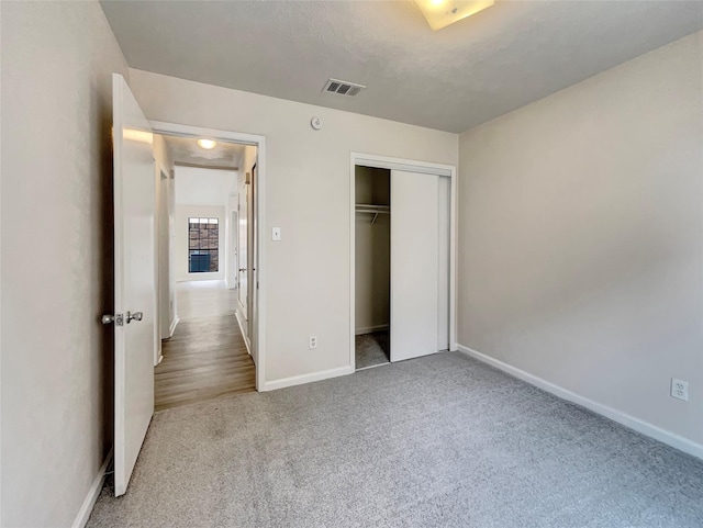 unfurnished bedroom with carpet flooring and a closet