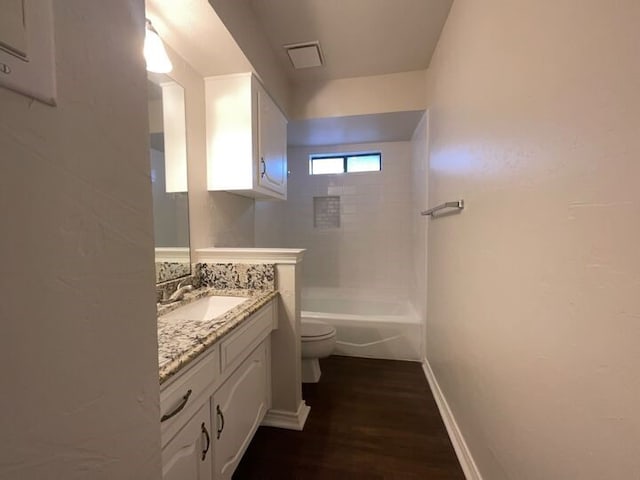 full bathroom with tiled shower / bath combo, hardwood / wood-style flooring, vanity, and toilet