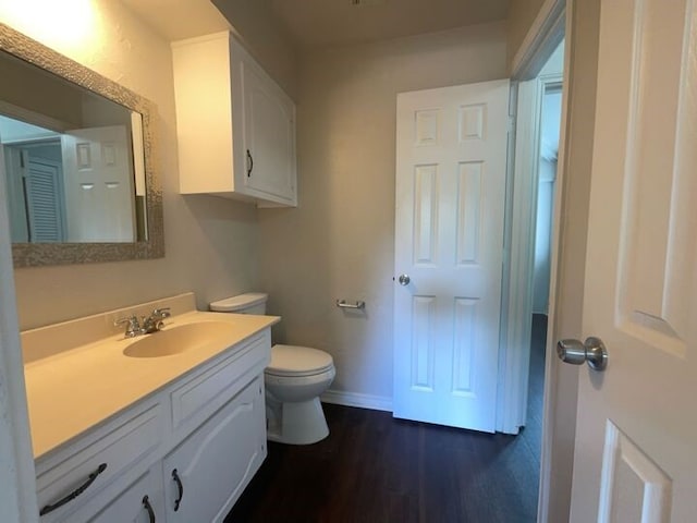 bathroom with vanity, toilet, and hardwood / wood-style flooring