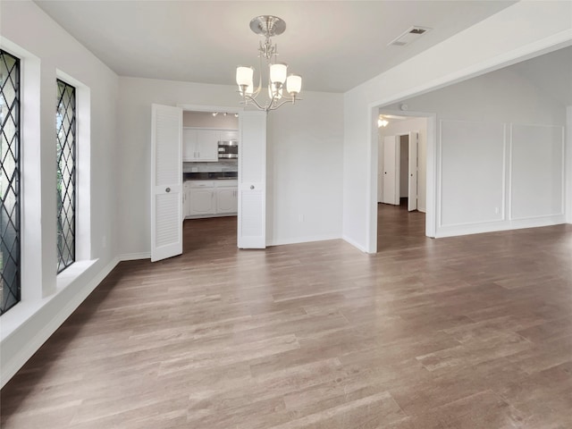 interior space with a notable chandelier and hardwood / wood-style floors