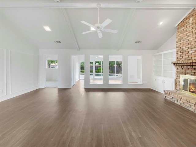 unfurnished living room with ceiling fan, beamed ceiling, dark wood-type flooring, high vaulted ceiling, and a fireplace