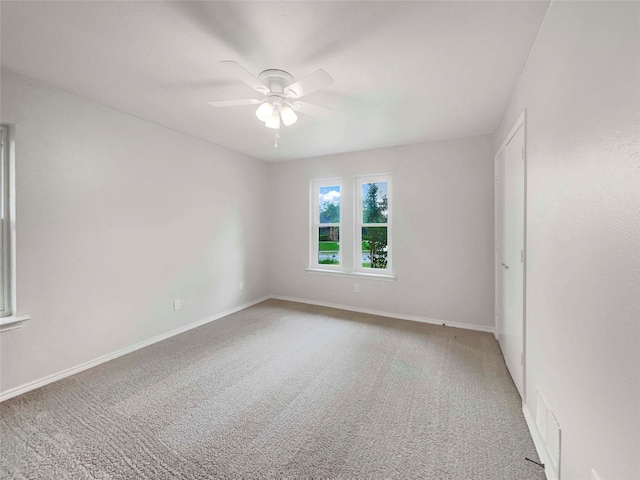 empty room with ceiling fan and carpet floors