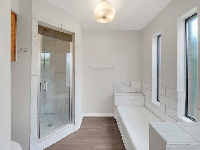 bathroom featuring hardwood / wood-style floors and plus walk in shower