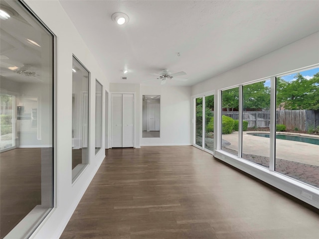 unfurnished sunroom with ceiling fan