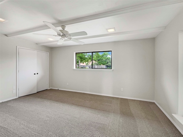 unfurnished room featuring beam ceiling, ceiling fan, and carpet floors